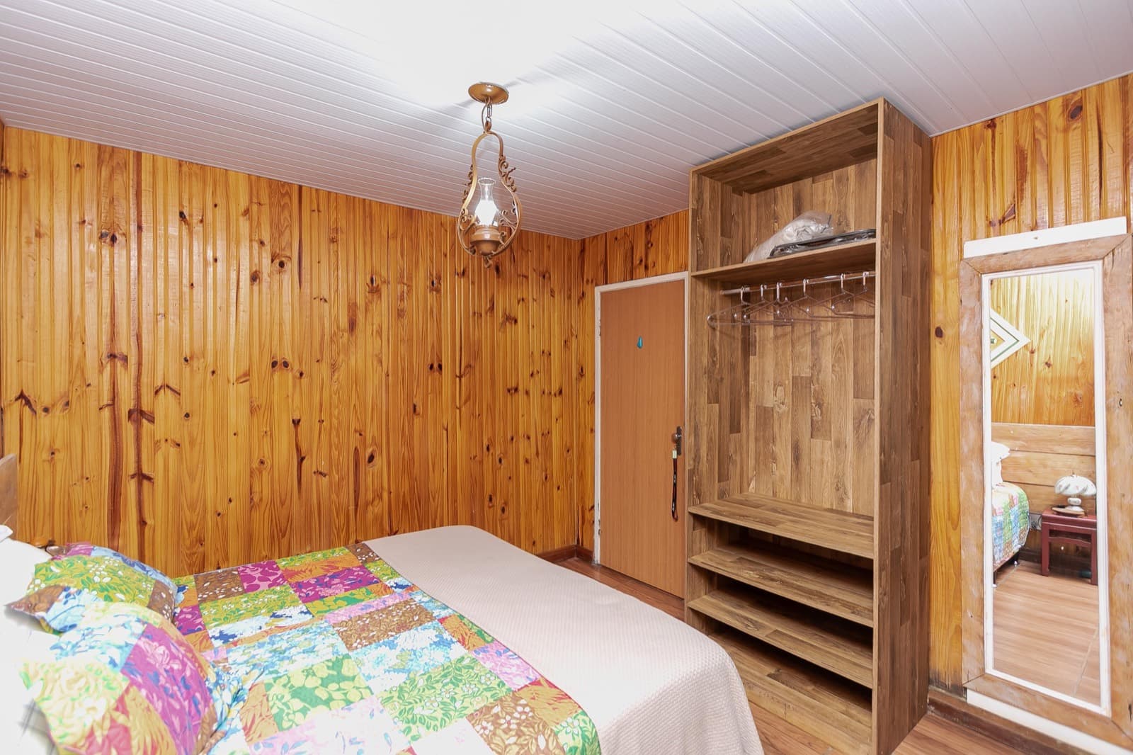 Suíte 1, com paredes de madeira e cama de casal