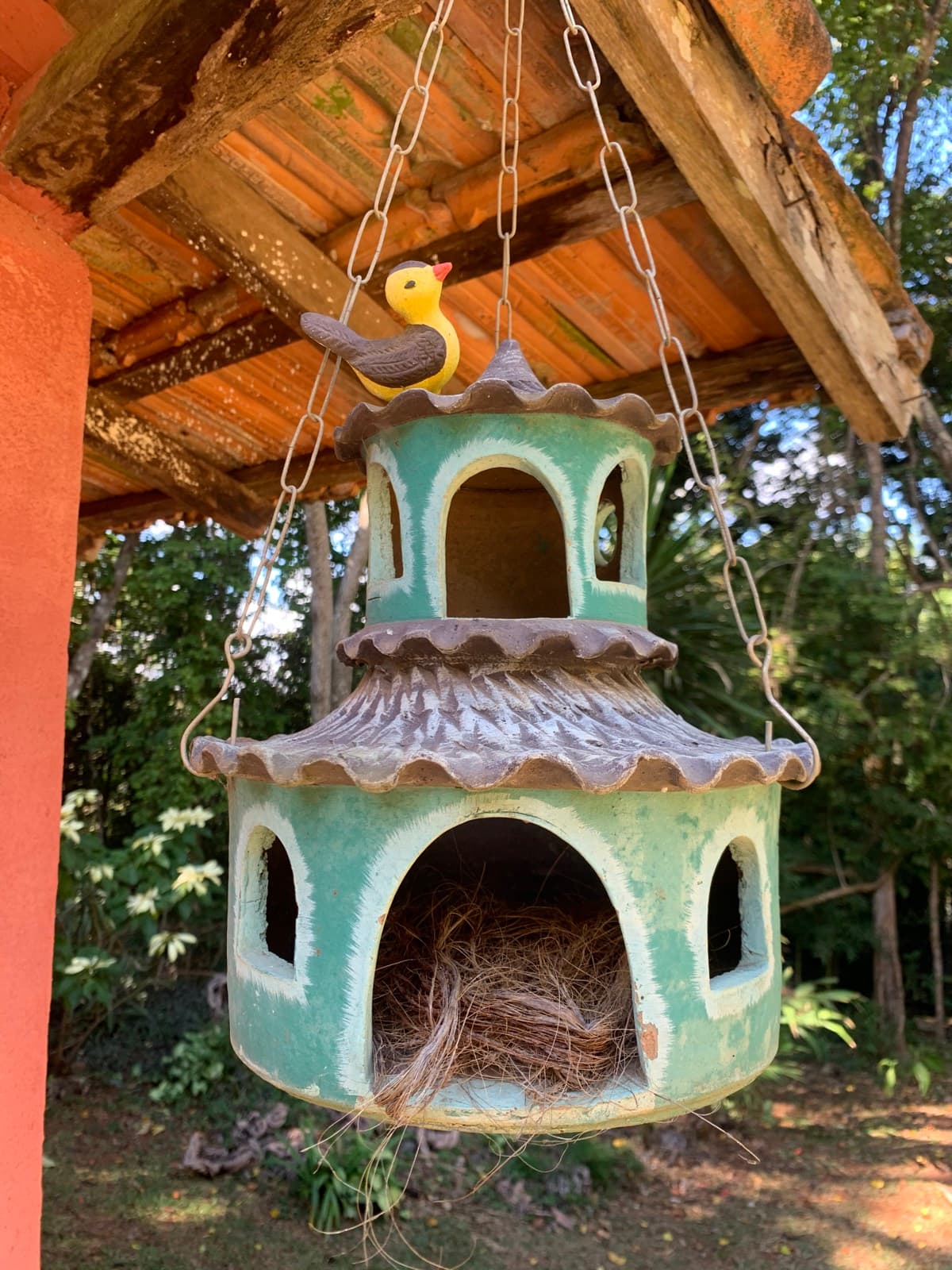 Casinha de passarinho de cerâmica pendurada na varanda